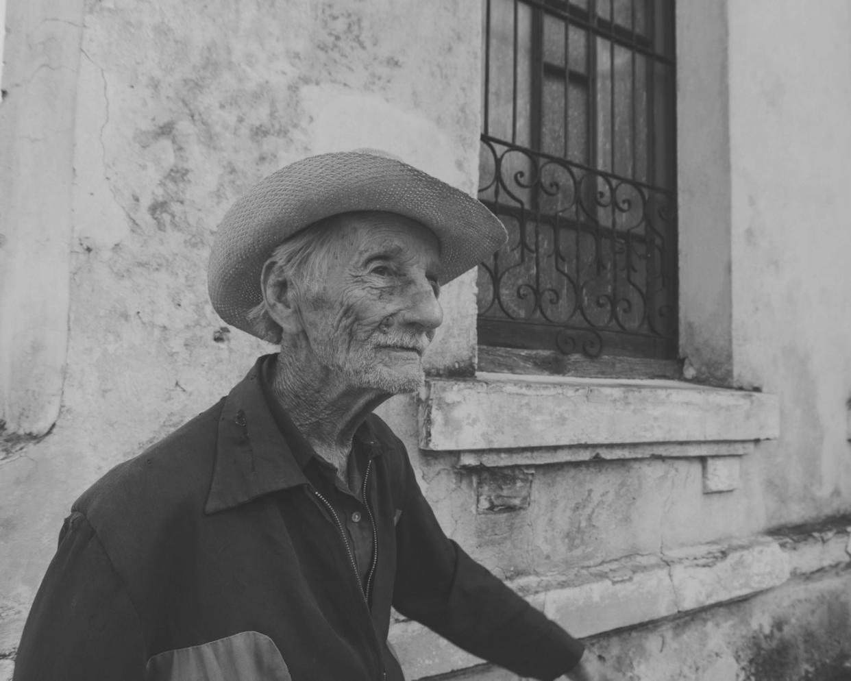 Professional caregiver assisting elderly individual with daily activities in comfortable home environment